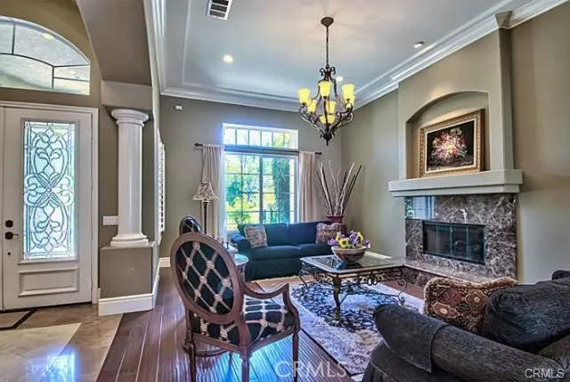 a living room with furniture a chandelier and a fireplace