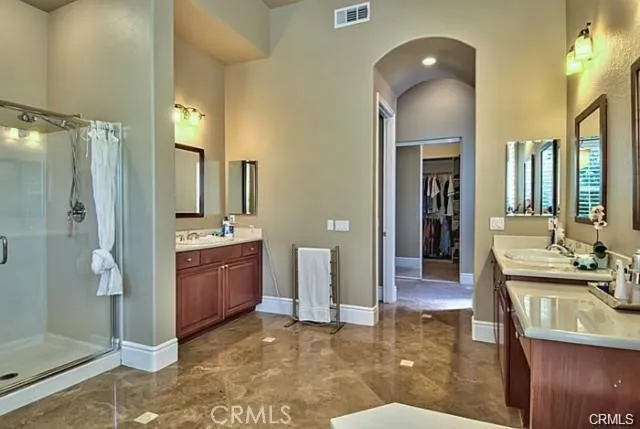 a spacious bathroom with a double vanity sink a mirror and a shower