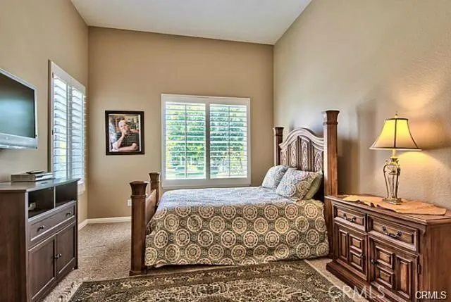 a bedroom with a bed wooden floor and flat screen tv