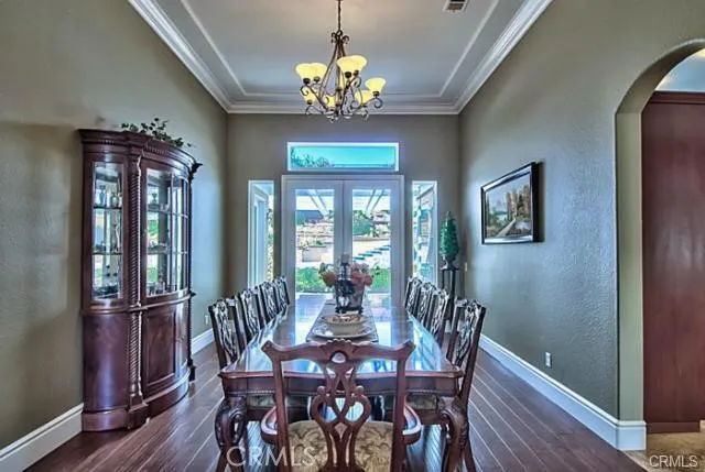 a view of a dining room with furniture a chandelier and wooden floor