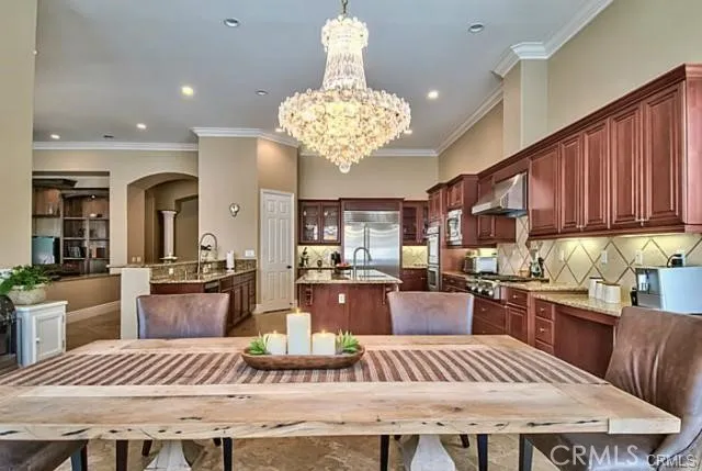 a kitchen with a stove a kitchen island a dining table and chairs with wooden floor