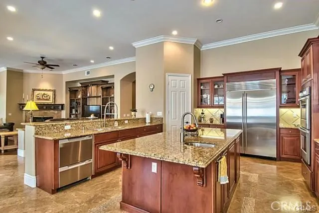 a kitchen with granite countertop kitchen island stainless steel appliances a sink stove and refrigerator