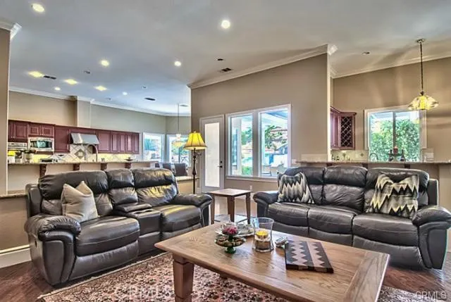 a living room with furniture kitchen view and a large window