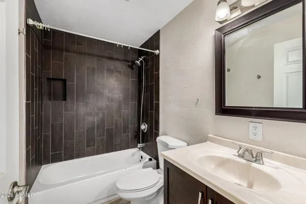 a bathroom with a sink a toilet a mirror and shower