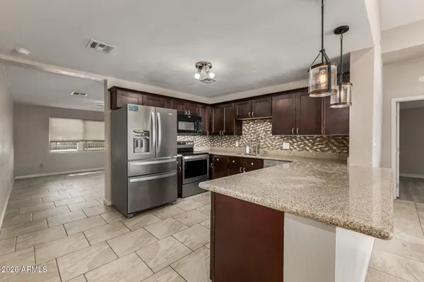 a kitchen with stainless steel appliances granite countertop a sink refrigerator and microwave