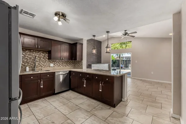 a spacious bathroom with a granite countertop sink a mirror and a bathtub