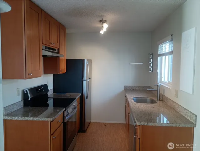 a kitchen with stainless steel appliances granite countertop a sink stove and refrigerator