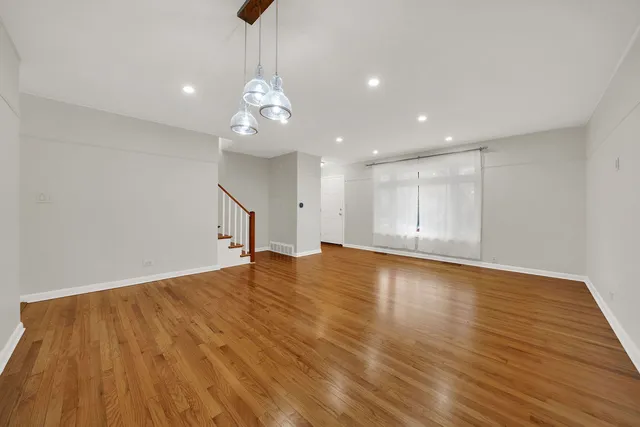 a view of empty room with wooden floor and ceiling fan