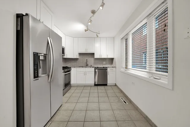 a kitchen with a refrigerator a sink and cabinets