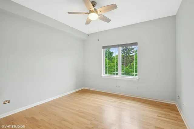 an empty room with a window and a ceiling fan
