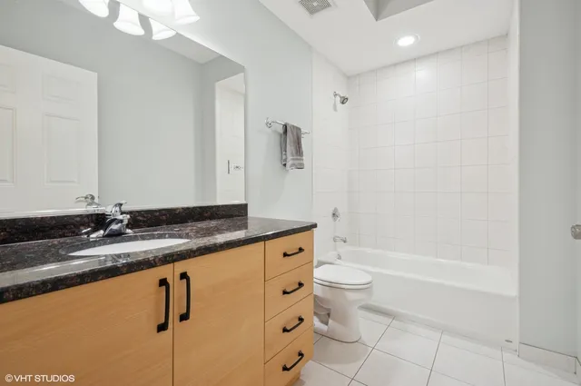 a bathroom with a granite countertop sink a toilet and bathtub