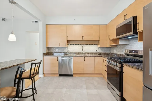 a kitchen with appliances a sink and cabinets