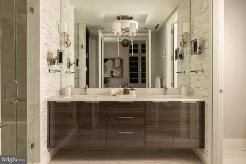 a bathroom with double vanity and a mirror