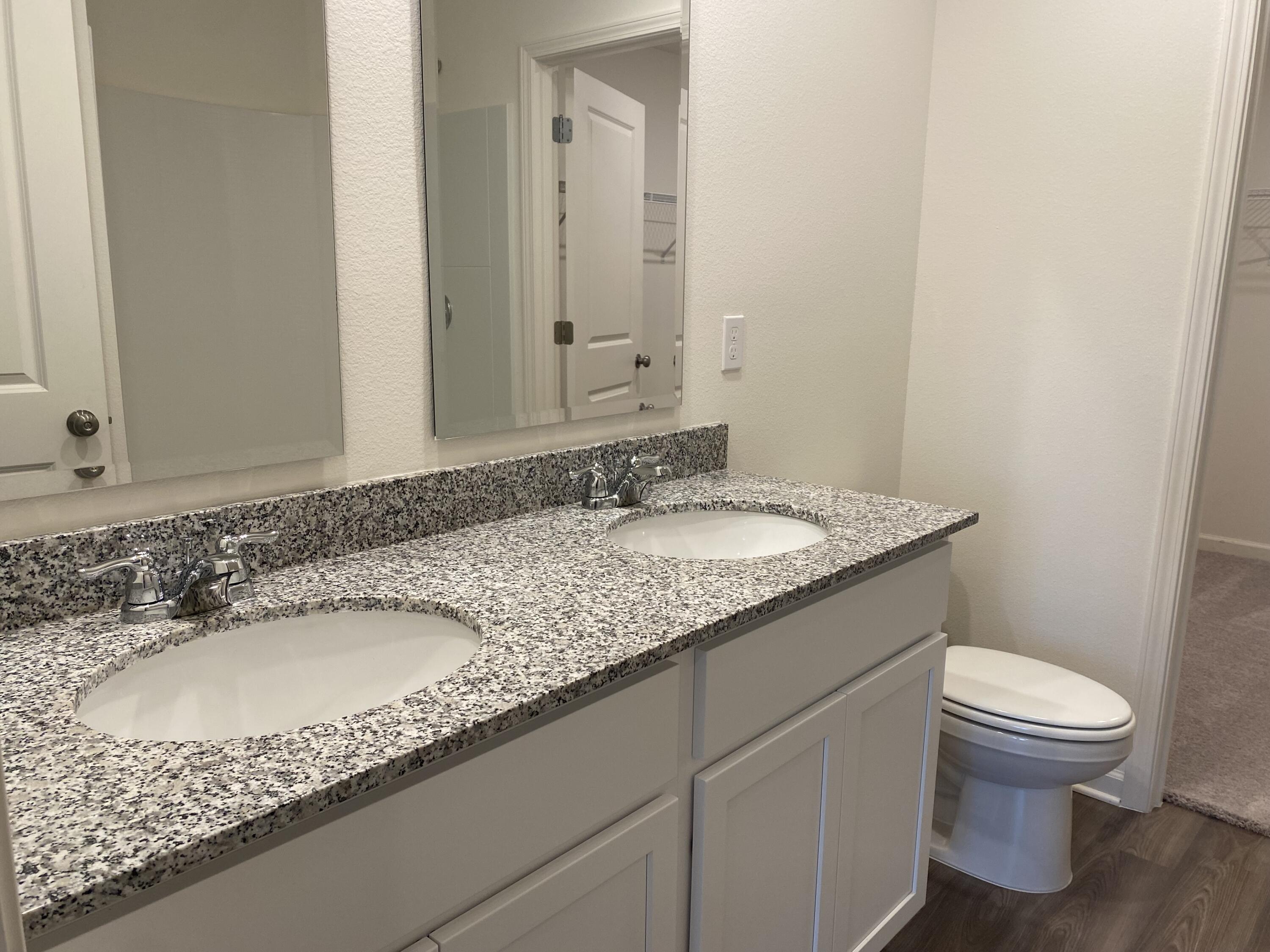 128 Squirrel Road DeFuniak Springs, FL 32433 - Photo 5 of 12 a bathroom with a granite countertop sink a toilet and a mirror