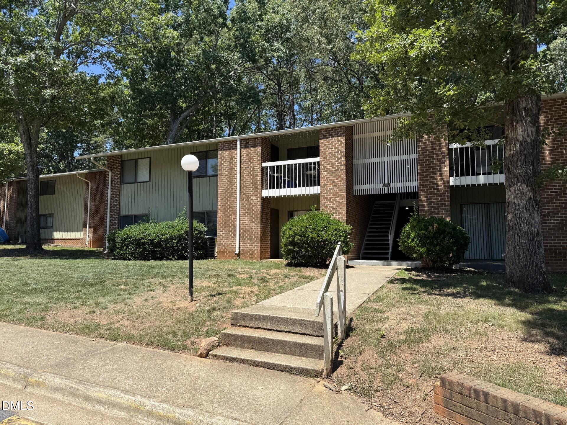 1299 Schaub Drive, Unit D Raleigh, NC 27606 - Photo 1 of 16 a front view of a house with a yard and potted plants