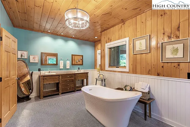 a spacious bathroom with a sink a chandelier and bathtub