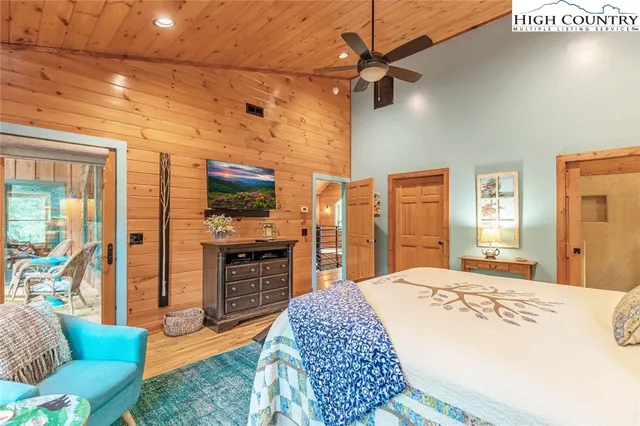 a spacious bedroom with a bed and glass windows