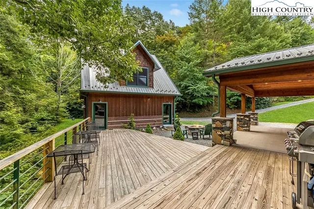 a view of house with a deck and furniture