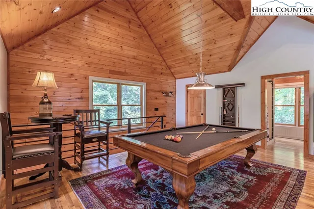a room with furniture pool table and windows