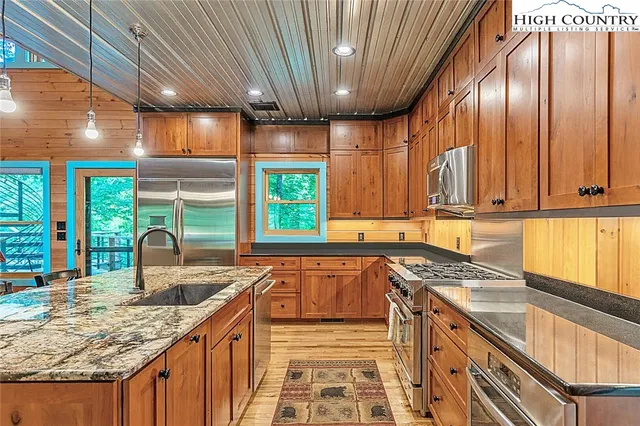 a kitchen with stainless steel appliances granite countertop a sink stove and cabinets