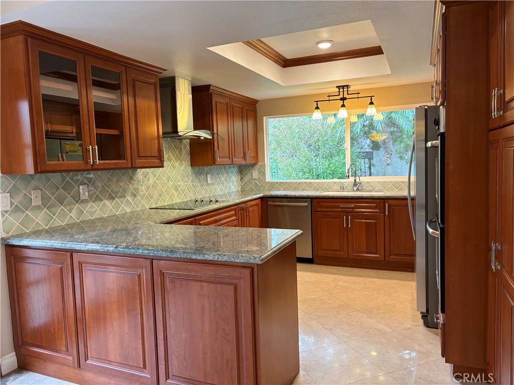 a kitchen with granite countertop a sink and wooden cabinets