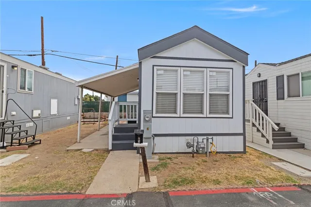a view of a house with a small yard and wooden floor and fence