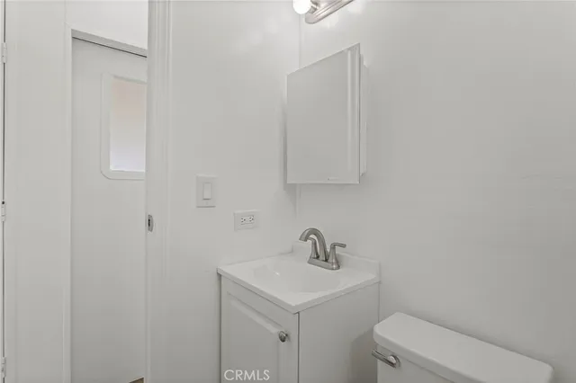 a bathroom with a sink a toilet and mirror