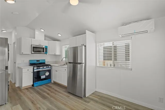 a kitchen with a refrigerator and a stove top oven