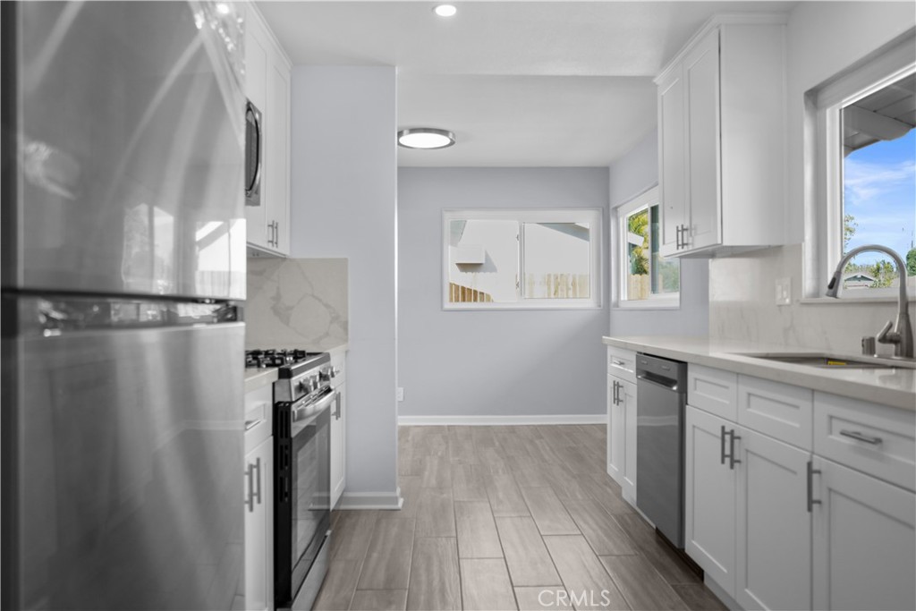 1791 Sitka Avenue Simi Valley, CA 93063 - Photo 23 of 44 a kitchen with granite countertop a refrigerator a sink and wooden floors