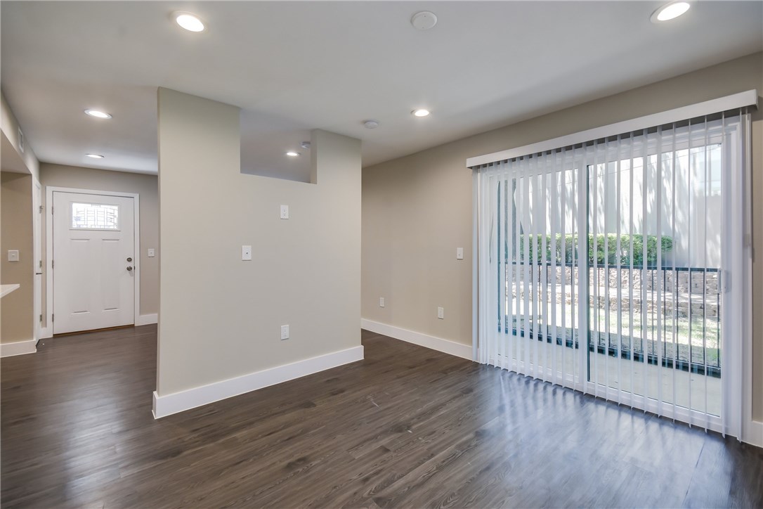 935 La Posada Drive, Unit 142 Austin, TX 78752 - Photo 16 of 28 an empty room with wooden floor and windows