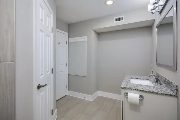a bathroom with a granite countertop sink and a mirror