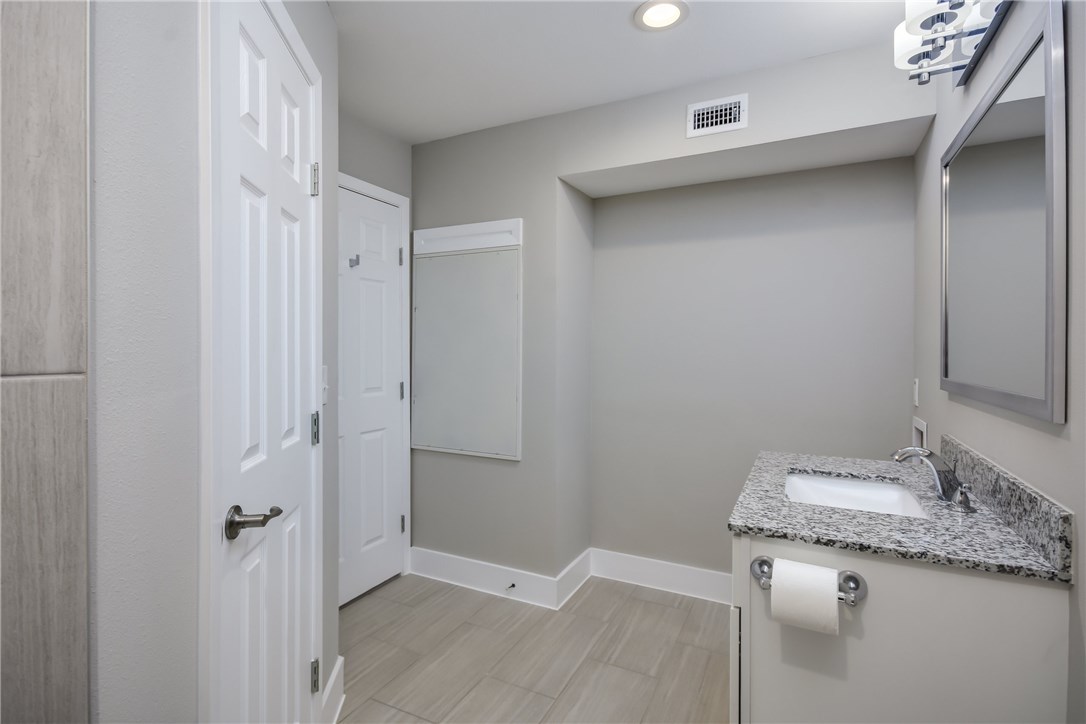935 La Posada Drive, Unit 142 Austin, TX 78752 - Photo 22 of 28 a bathroom with a granite countertop sink and a mirror