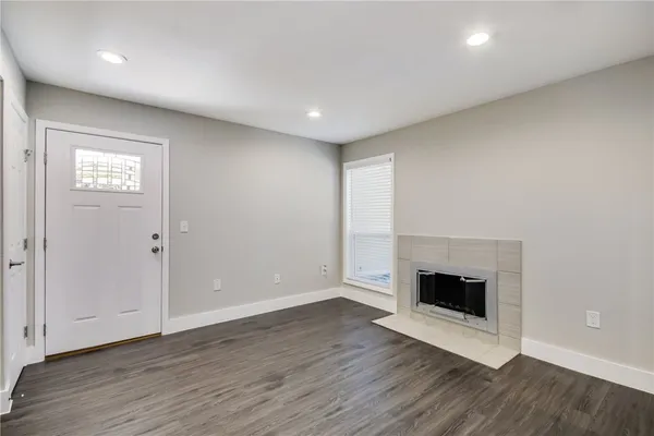 an empty room with wooden floor and fireplace