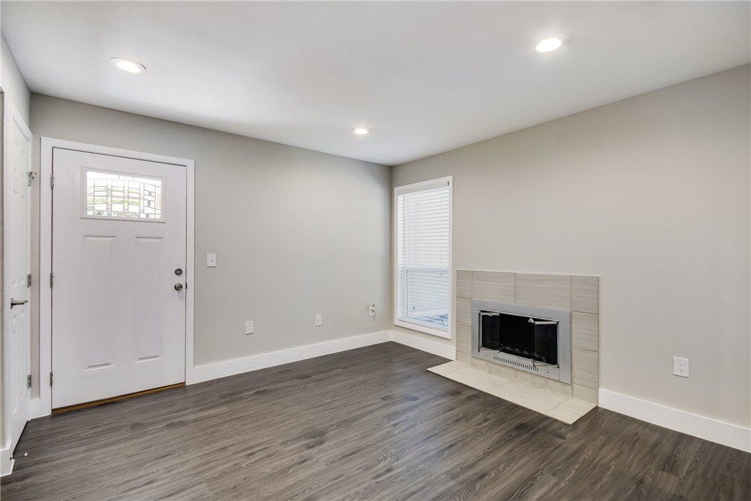 935 La Posada Drive, Unit 142 Austin, TX 78752 - Photo 10 of 28 an empty room with wooden floor and fireplace