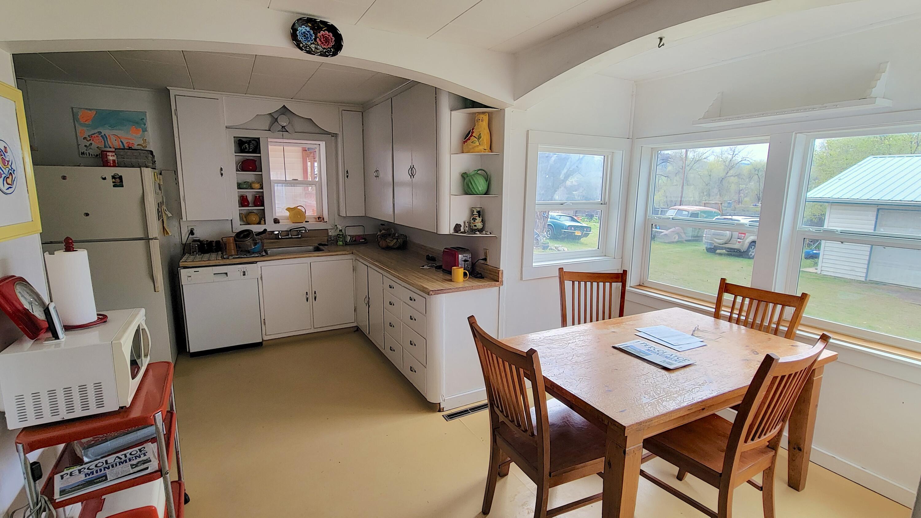298 Main Street Monument, OR 97864 - Photo 12 of 66 a kitchen with a table chairs and a refrigerator