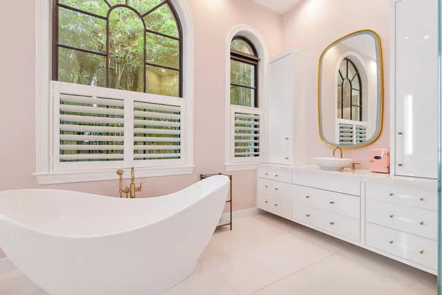 a spacious bedroom with a bed and a lamp next to a window