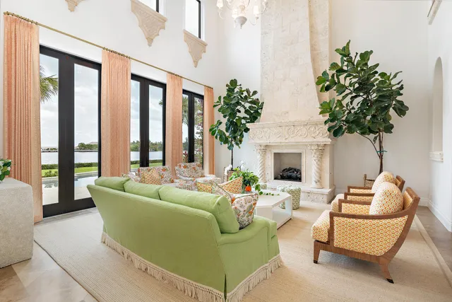a living room with furniture a fireplace and a chandelier