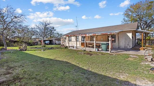 a view of a house with backyard and sitting area