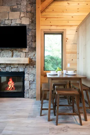 a open kitchen with stainless steel appliances granite countertop a stove a refrigerator a dining table and chairs with wooden floor