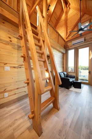 a open kitchen with stainless steel appliances granite countertop a sink dishwasher a stove a microwave oven with white cabinets and wooden floor