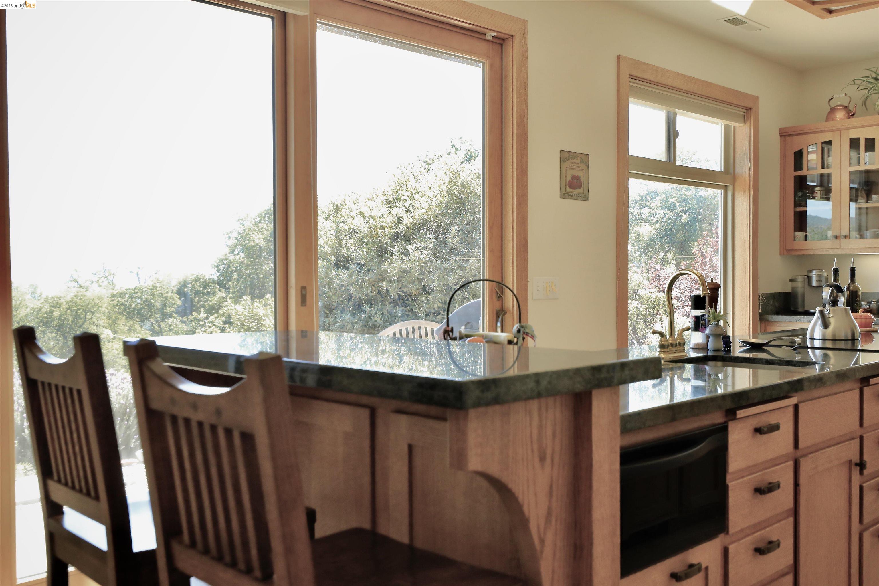18288 Lambert Lake Road Sonora, CA 95370 - Photo 14 of 55 Kitchen featuring glass insert cabinets, wood finish cabinets, dark stone countertops, a warming drawer, and black microwave