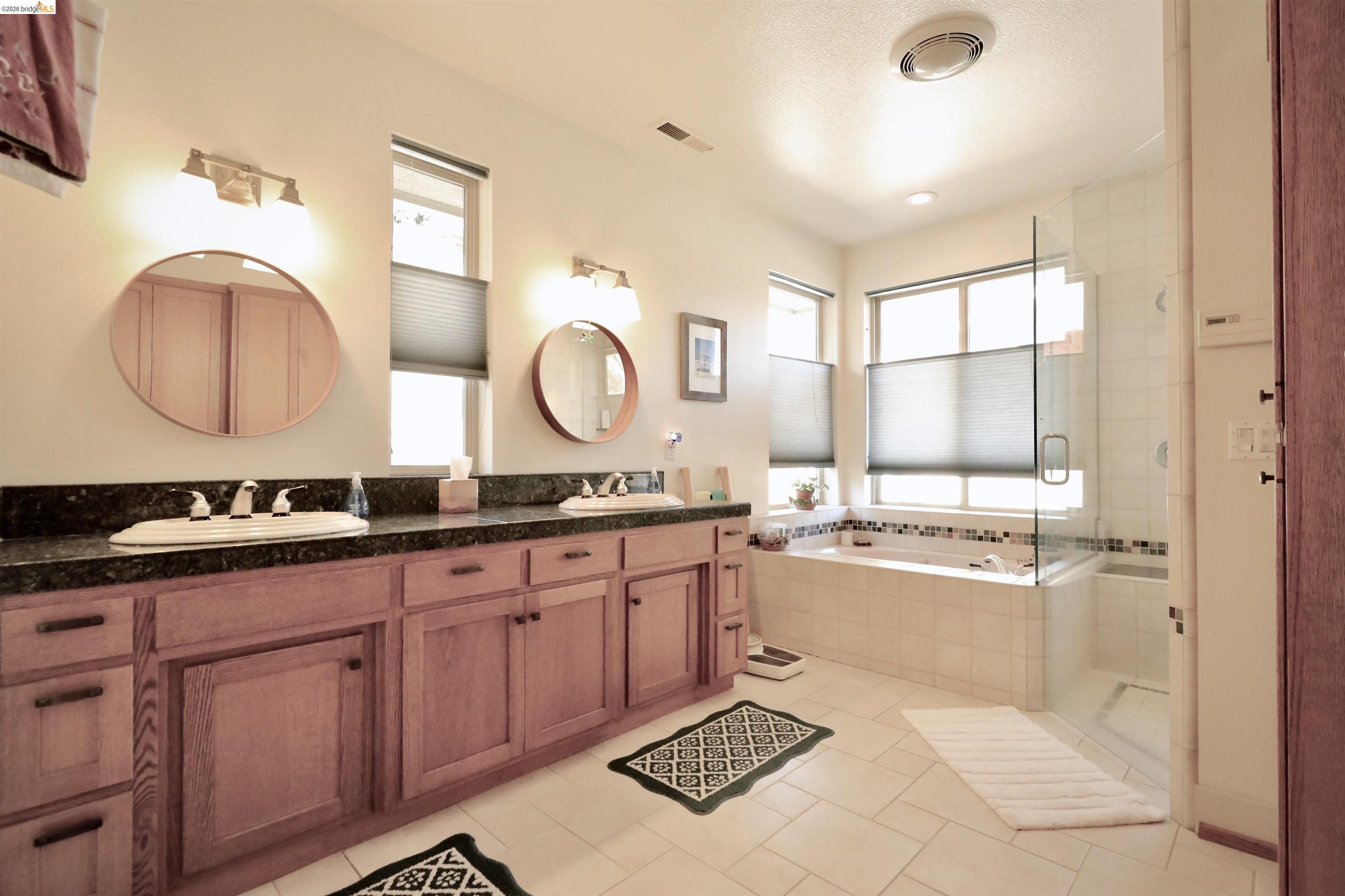 18288 Lambert Lake Road Sonora, CA 95370 - Photo 24 of 55 Bathroom featuring double vanity, a shower stall, a garden tub, and light tile patterned flooring