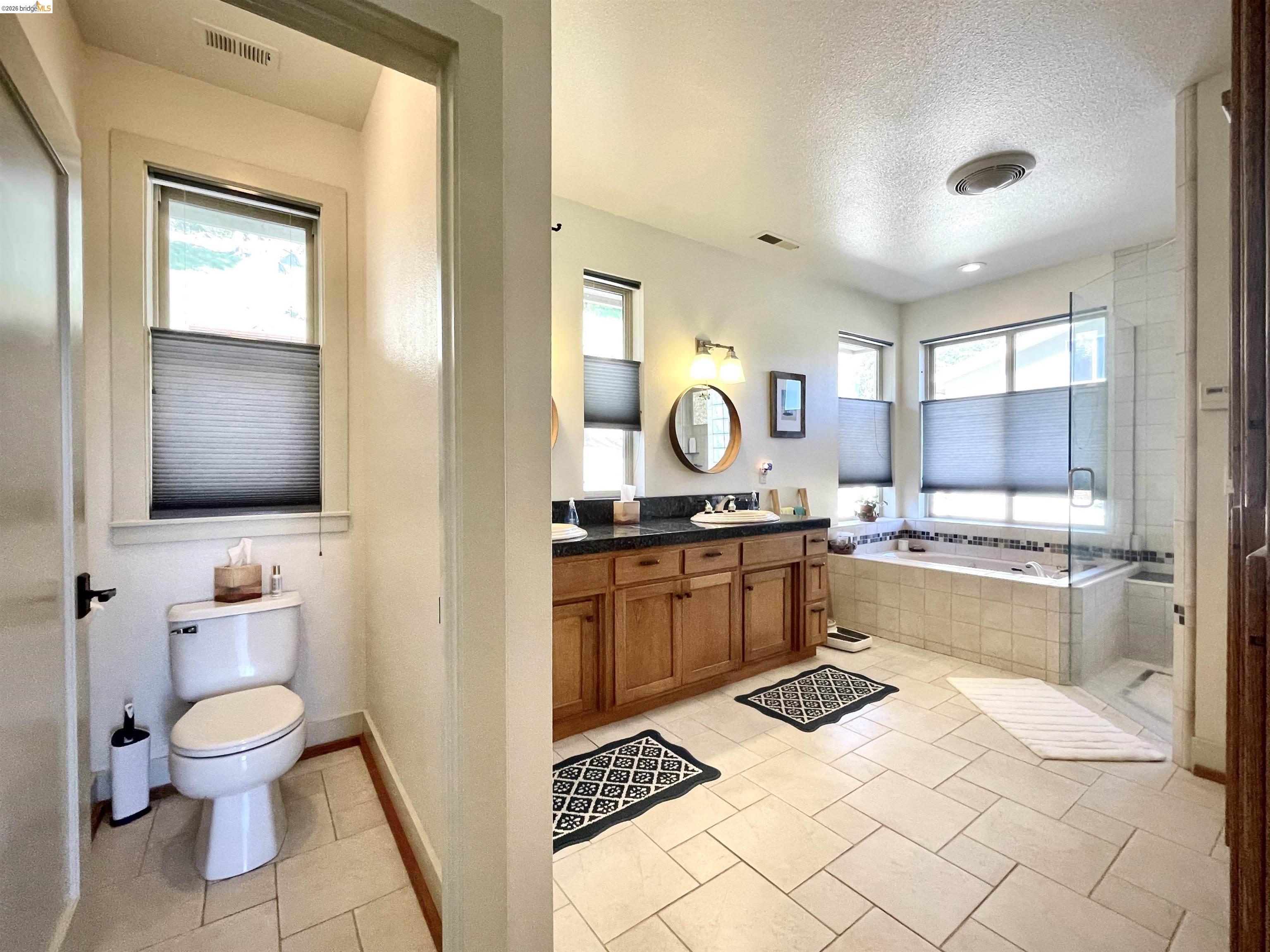 18288 Lambert Lake Road Sonora, CA 95370 - Photo 26 of 55 Bathroom with double vanity, a textured ceiling, a bath, light tile patterned flooring, and a shower stall
