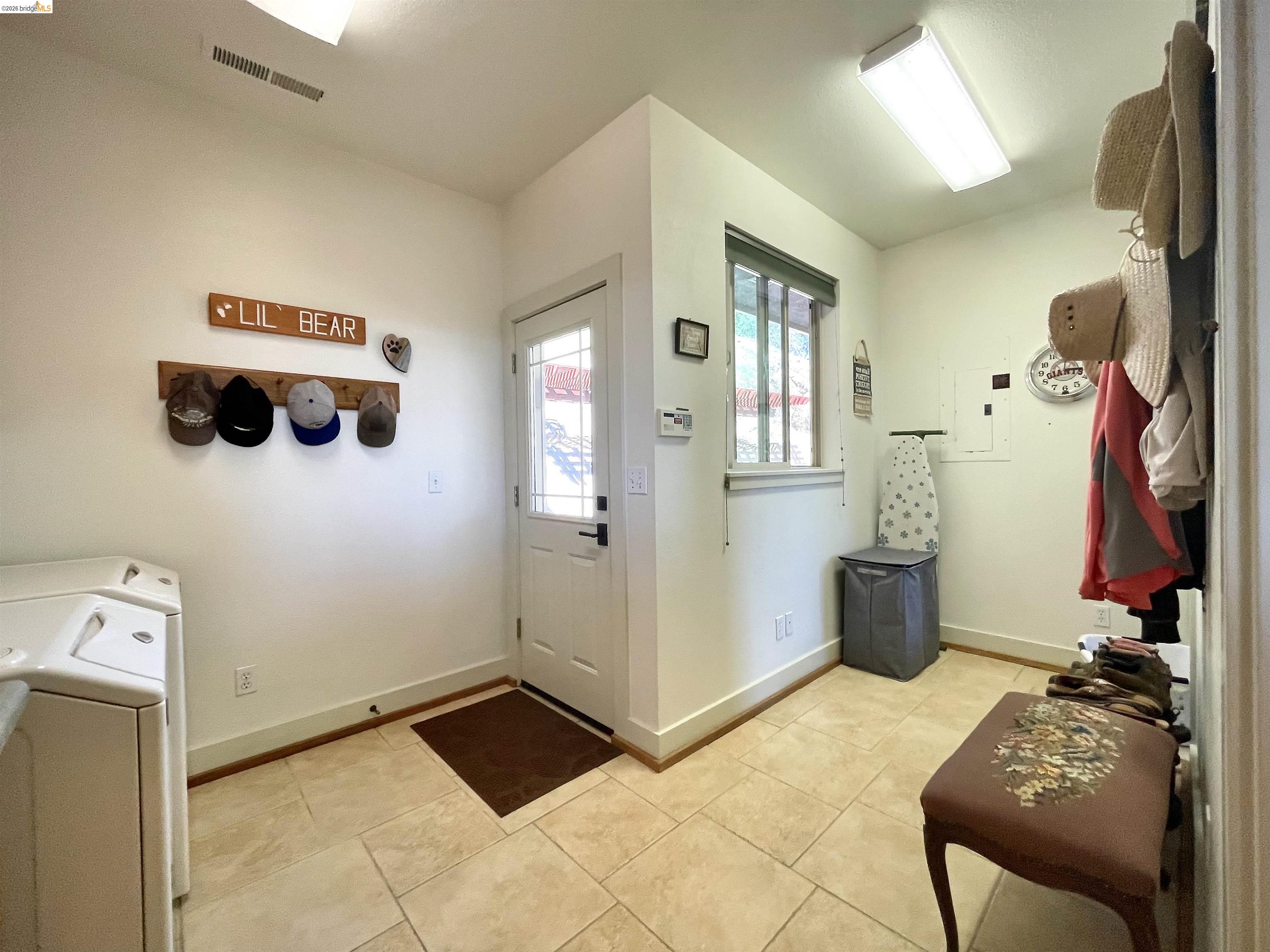 18288 Lambert Lake Road Sonora, CA 95370 - Photo 38 of 55 Mudroom with washing machine and dryer, light tile patterned flooring, and electric panel