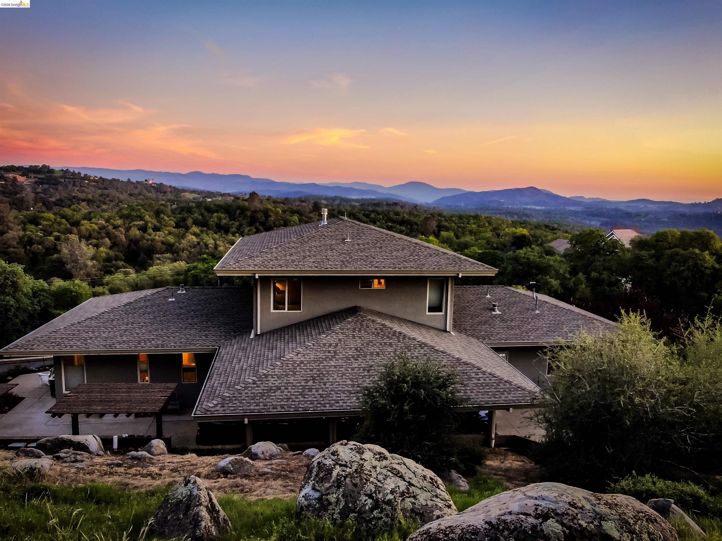18288 Lambert Lake Road Sonora, CA 95370 - Photo 44 of 55 Back of property at dusk featuring roof with shingles and a mountain view