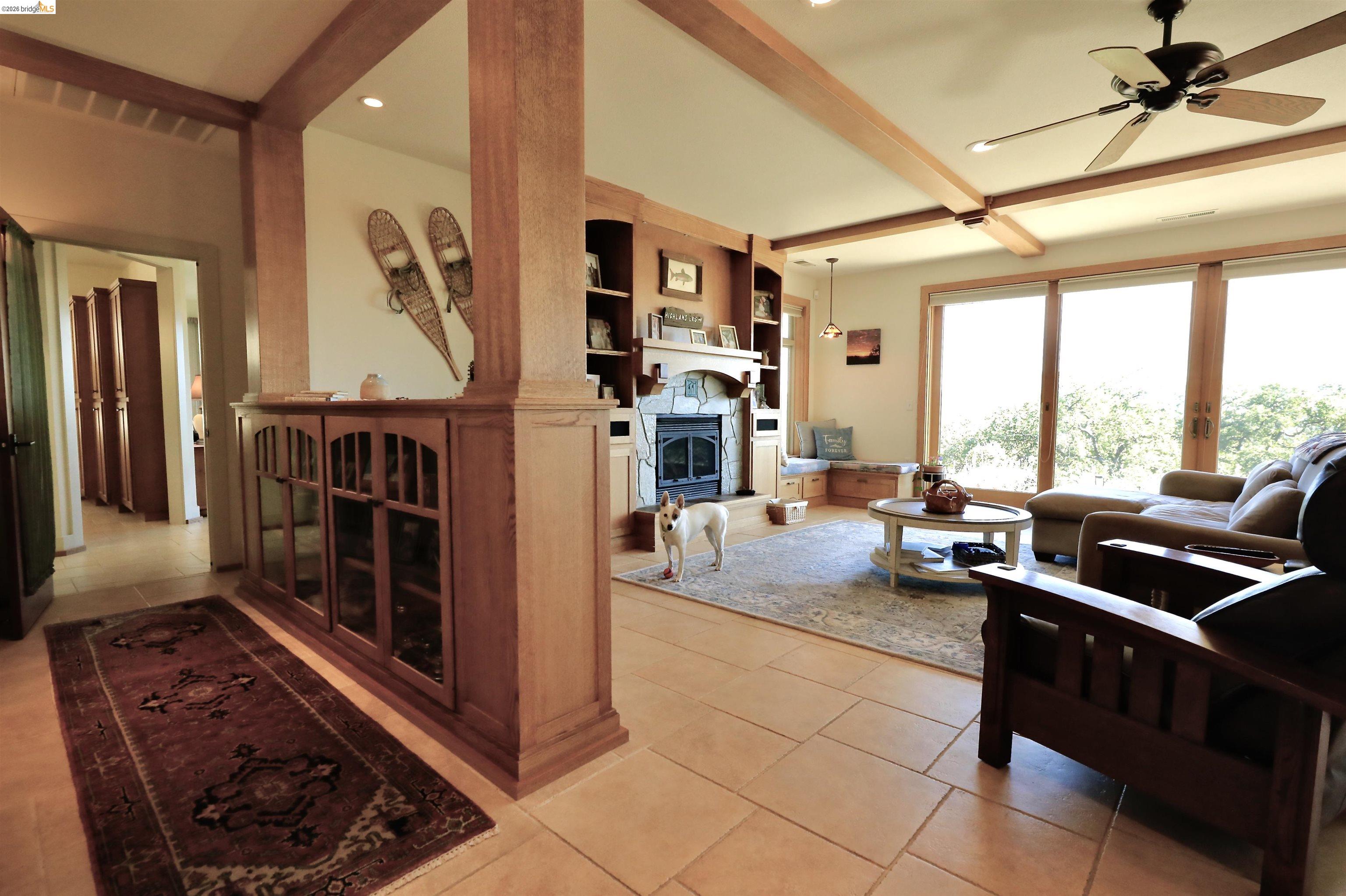 18288 Lambert Lake Road Sonora, CA 95370 - Photo 8 of 55 Living area featuring beam ceiling, a ceiling fan, light tile patterned floors, a fireplace with raised hearth, and recessed lighting
