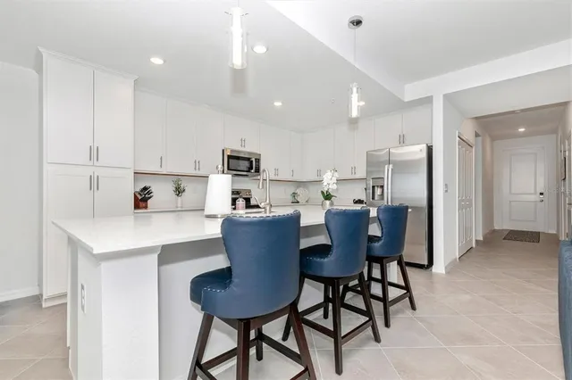 a kitchen with a dining table chairs and white cabinets