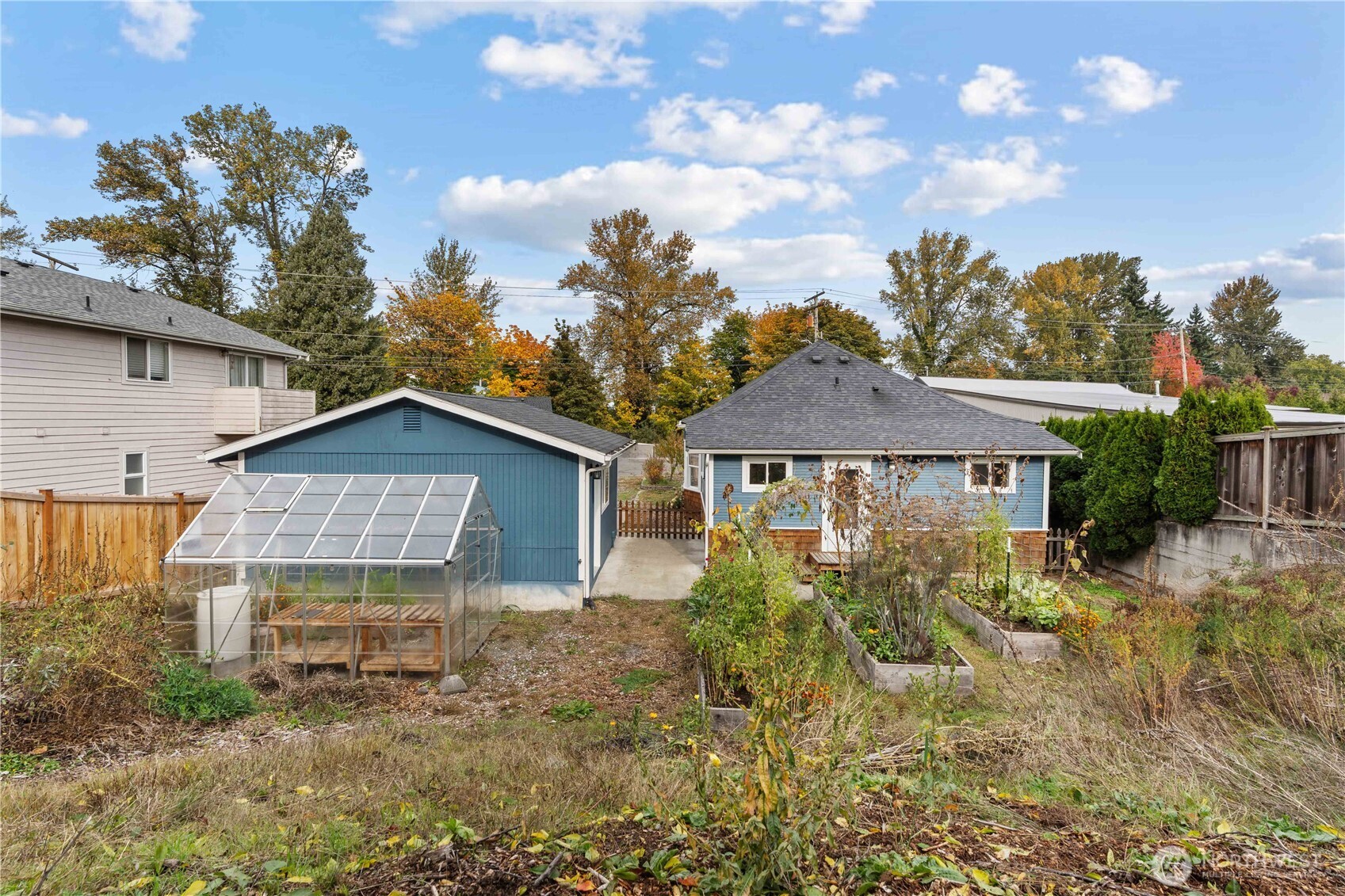 624 West Main Street Sumner, WA 98390 - Photo 26 of 34 a view of a brick house next to a yard with plants and large trees