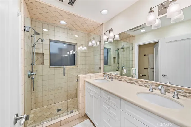a bathroom with a shower sink double and mirror