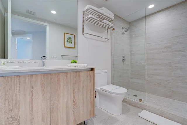 a bathroom with a double vanity sink toilet and shower